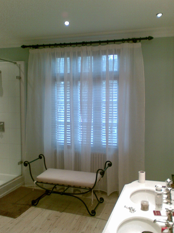 Voile curtain on a pole in front of woodslat blind Islington North London